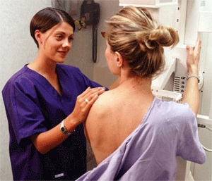 协助女性患者进行乳房x光检查的医生